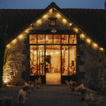 Entrée de salle de réception de mariage avec des guirlandes lumineuses aux gîtes du berger