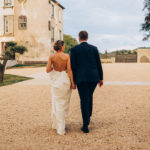 couple de mariés qui marchent devant le chateau de chignat