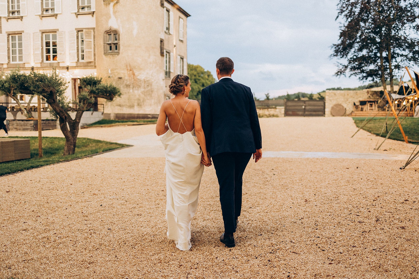 couple de mariés qui marchent devant le chateau de chignat